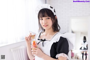 A woman in a maid outfit posing for a picture.