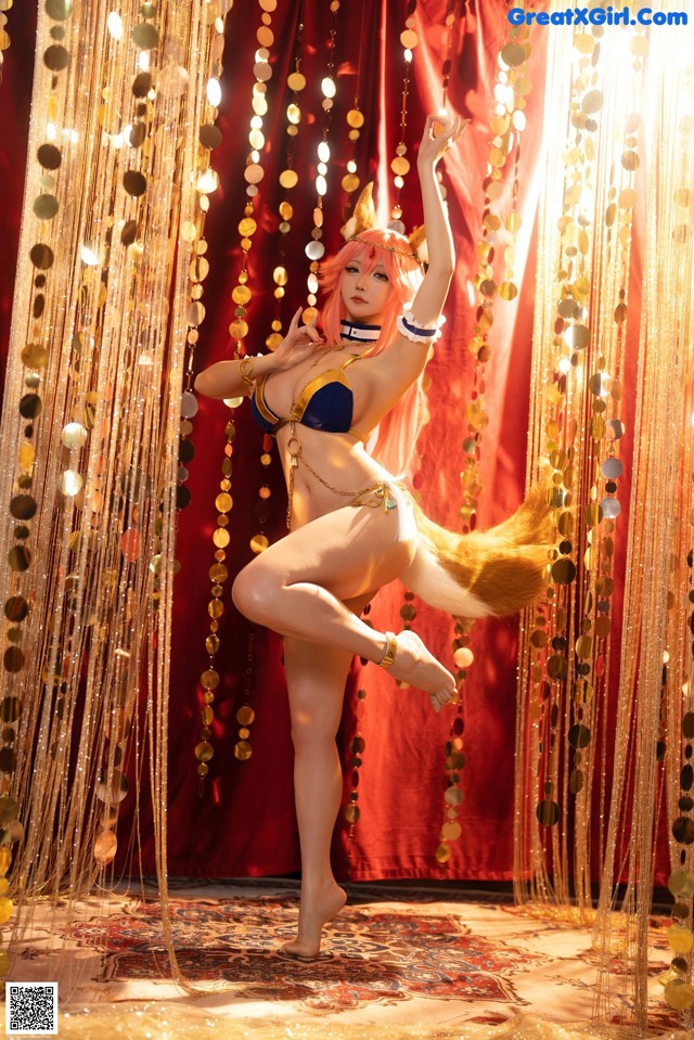 A woman in a bikini is dancing in front of a curtain.
