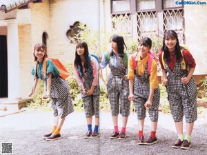 A group of young women walking across a lush green field.
