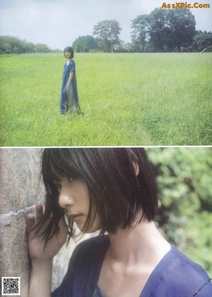 A woman in a blue dress standing in the woods.