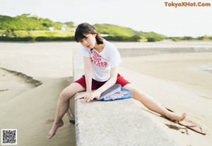 A woman standing on the edge of a body of water.