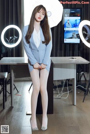 A woman sitting on top of a table next to a mirror.