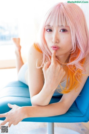 A woman with pink hair wearing a black shirt.