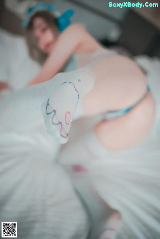 A pregnant woman laying on a bed with a pillow.