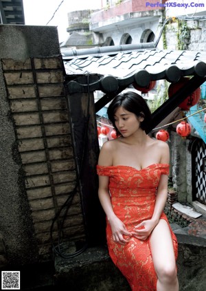 A woman in a red bikini laying on a blanket.