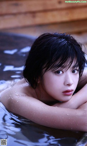 A woman laying on the edge of a swimming pool.
