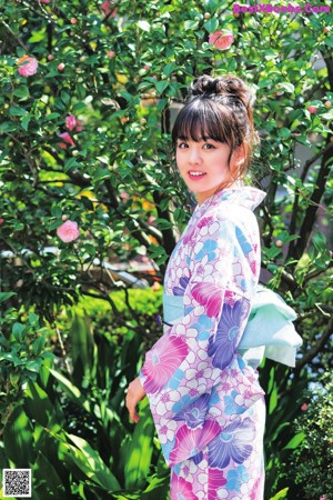 A woman in a green and blue kimono sitting on the floor.