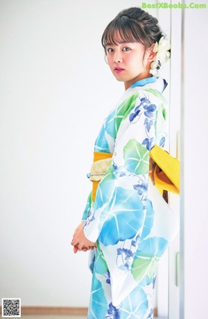 A woman in a pink and blue kimono posing for a picture.