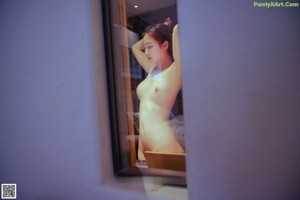 A woman in a black lingerie posing for the camera.