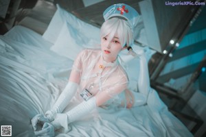 A woman dressed as a nurse standing in a bathroom.
