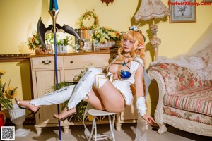 A woman in a white and blue outfit sitting on a chair.
