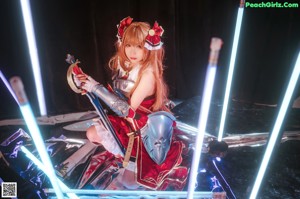 A woman in a red and black outfit sitting on a table.