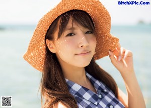 A woman standing on a wooden dock looking out at the ocean.