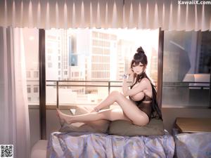 A woman sitting on a stool in a black lingerie.