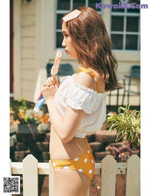 A woman in a bathing suit holding a drink in front of a Starbucks.