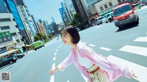A woman in a pink shirt and white shorts is posing for a picture.