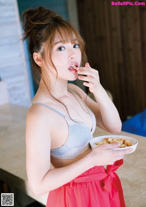 A woman in a striped shirt holding a cup of coffee.