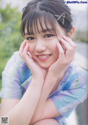 A young woman with long black hair and bangs posing for a picture.