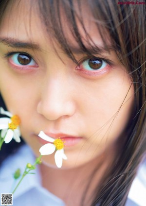 A woman in a bikini with a flower in her mouth.