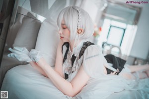 A woman in lingerie sitting on a bed.