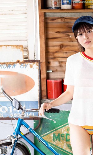 A woman in an orange bikini leaning against a window.