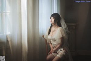 A woman in a wedding dress and stockings laying on a couch.