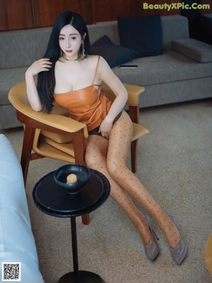a woman in a brown dress sitting on a ledge