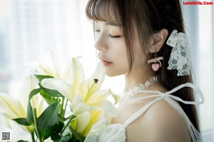 A woman in a white dress holding a bouquet of flowers.