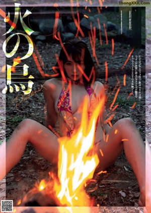 A woman in a red bikini standing next to a fire.