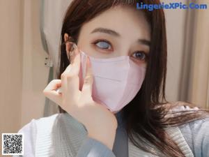 A woman wearing a face mask is posing for the camera.