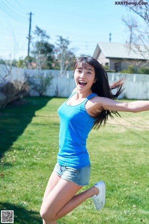 A woman in a gray shirt and pink shorts posing for a picture.