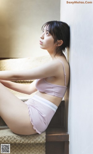 A woman laying on the floor with her back to the camera.